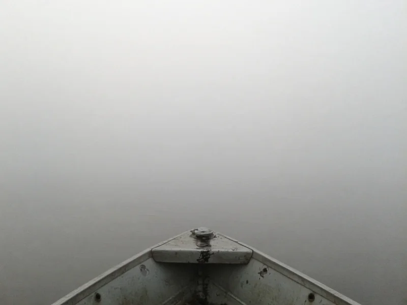 Gęsta mgła nad wodą, brzeg i struktura niewidoczne